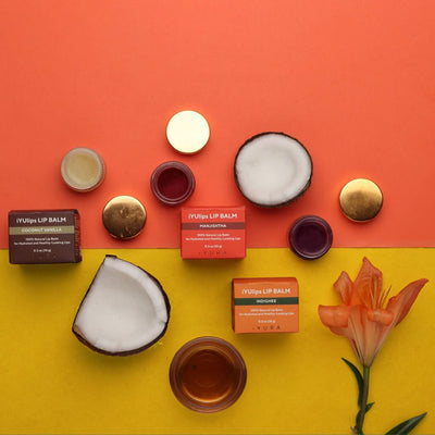iYUlips: 100% Natural Ayurvedic Lip Balms with an orange and yellow background containing a flower and pieces of coconut